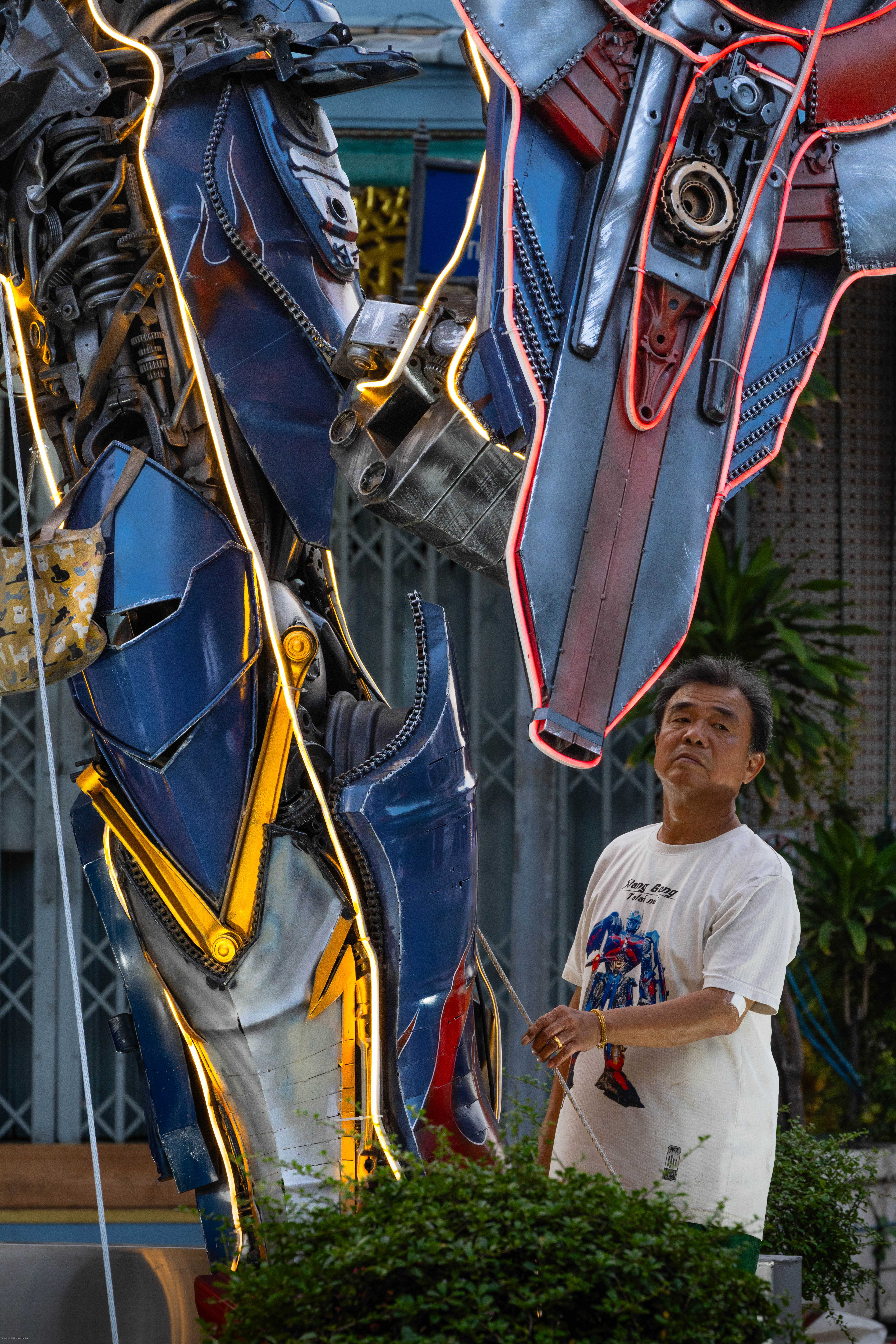Man in T-Shirt testing guy wires for statue