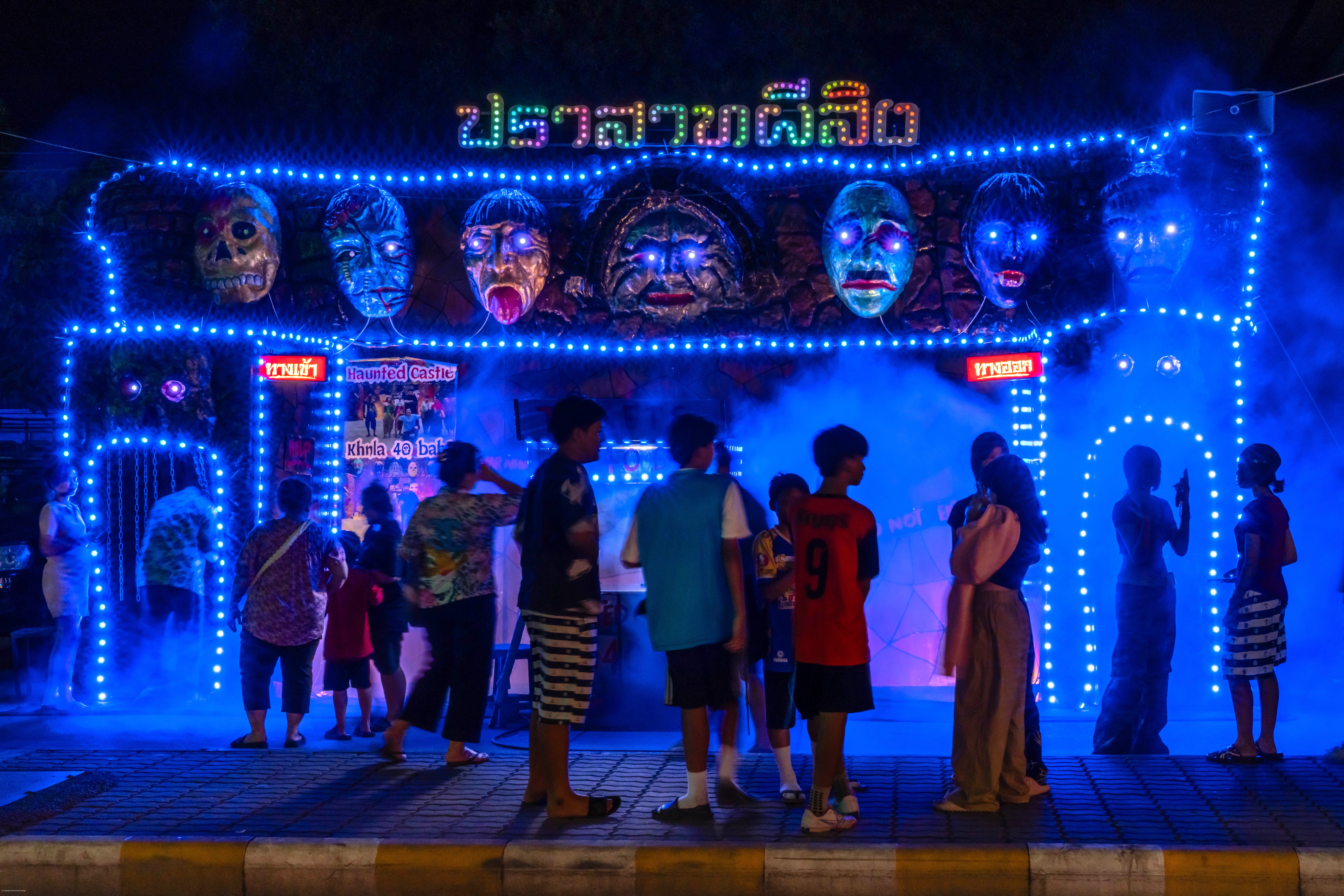 Customers standing before a haunted house.