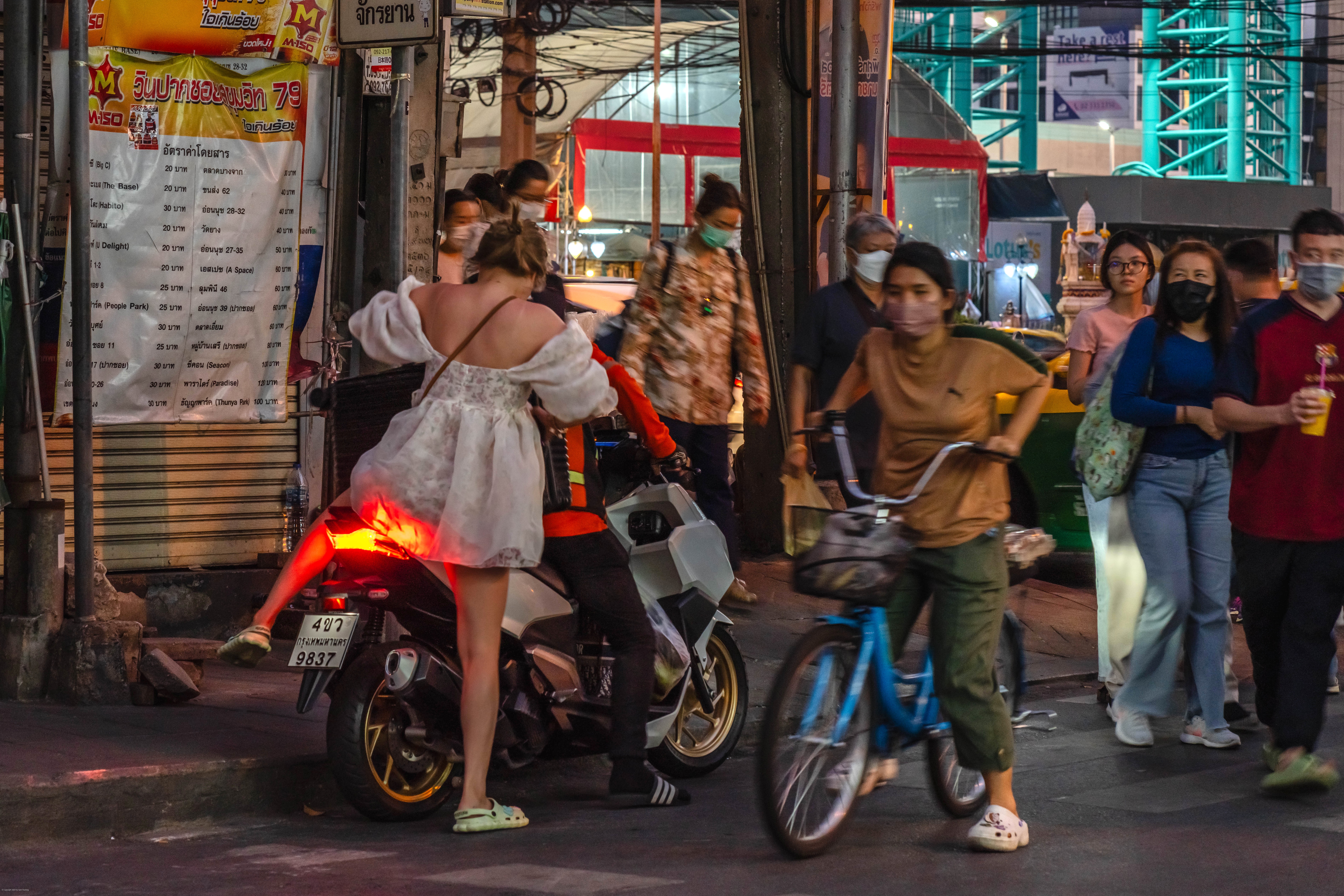 A girl mounts her motorcycle.
