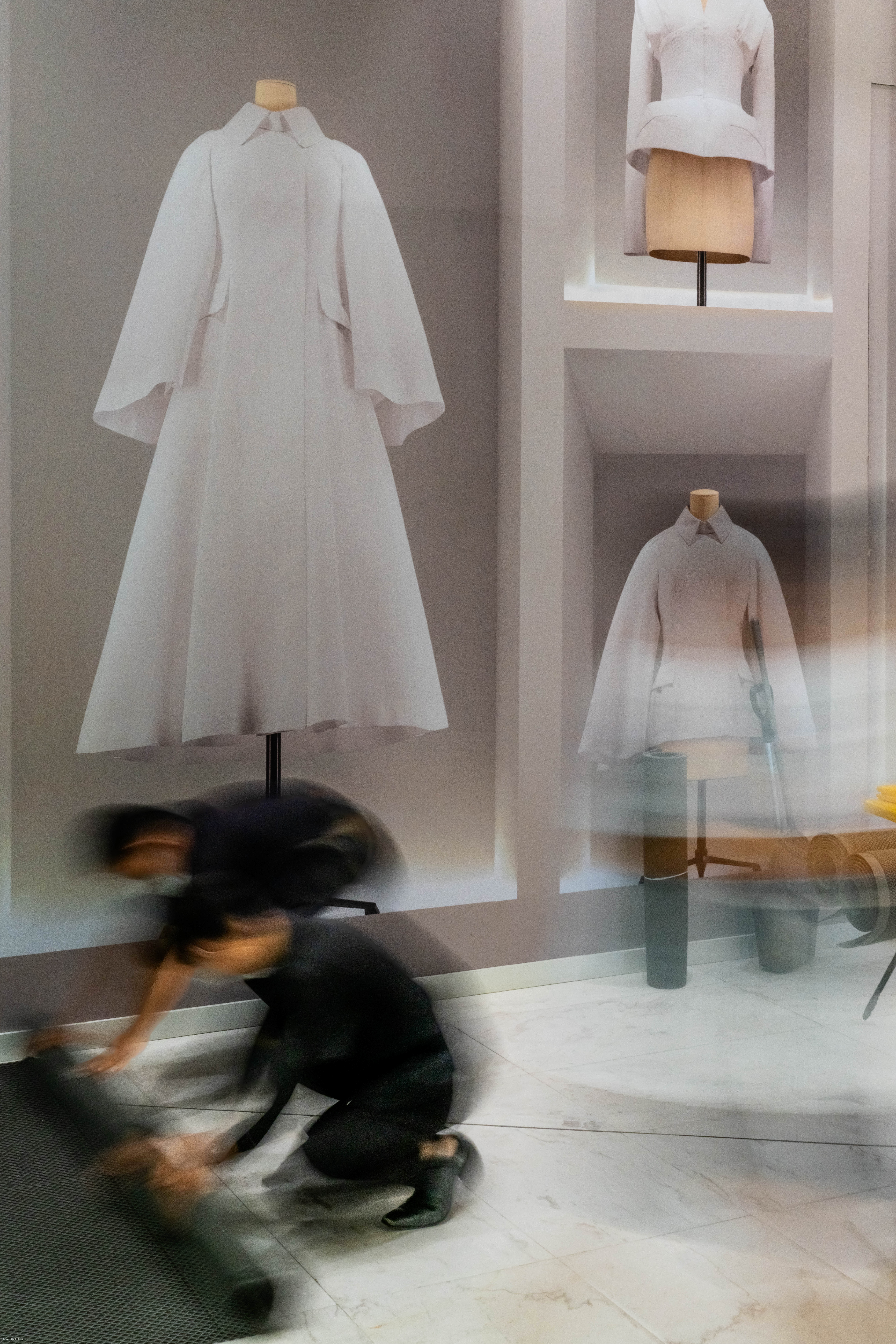 Two workers rolling up a carpet at Em Quartier mall.