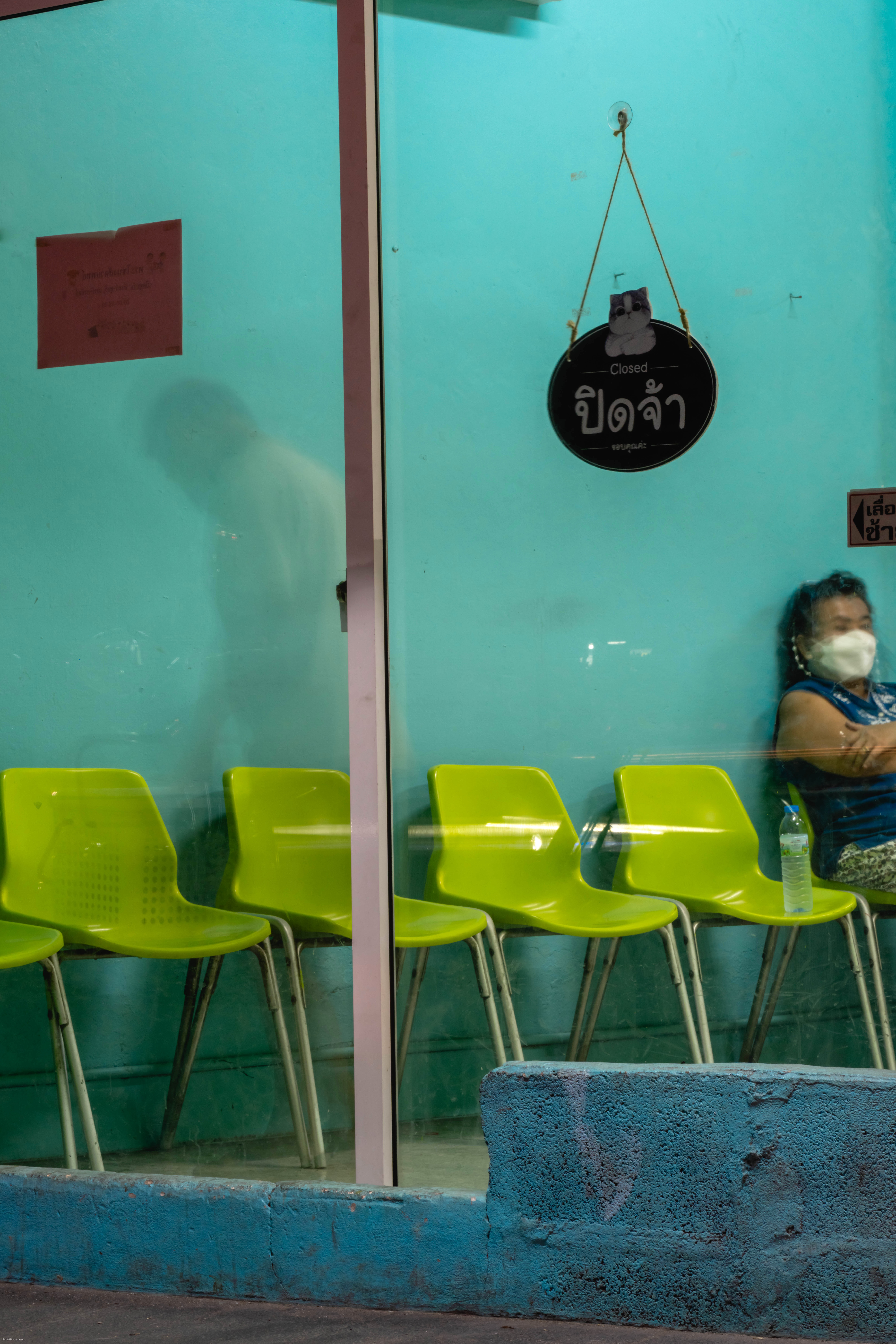 A seated woman waits at a clinic.