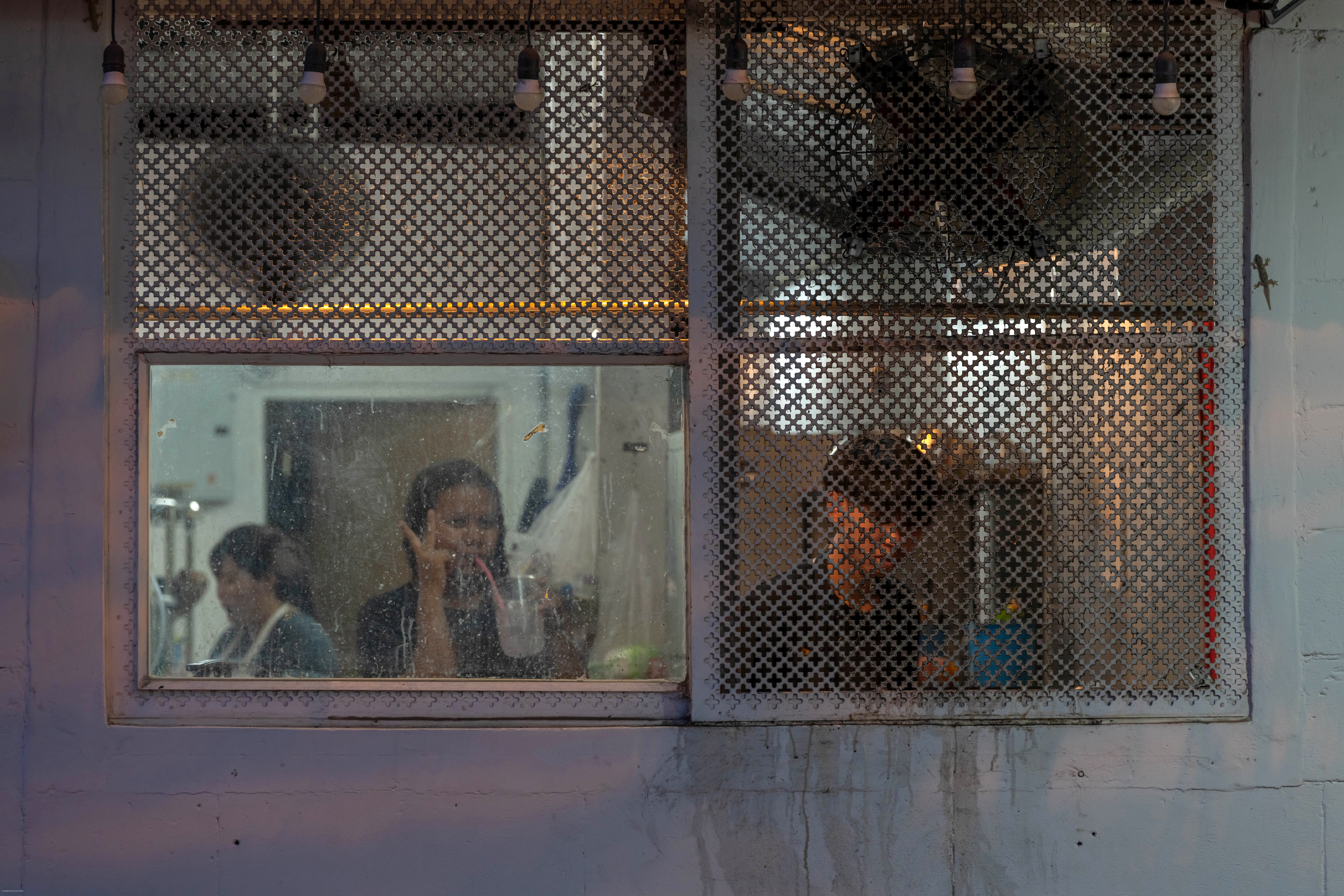 Restaurant workers behind a window at night.