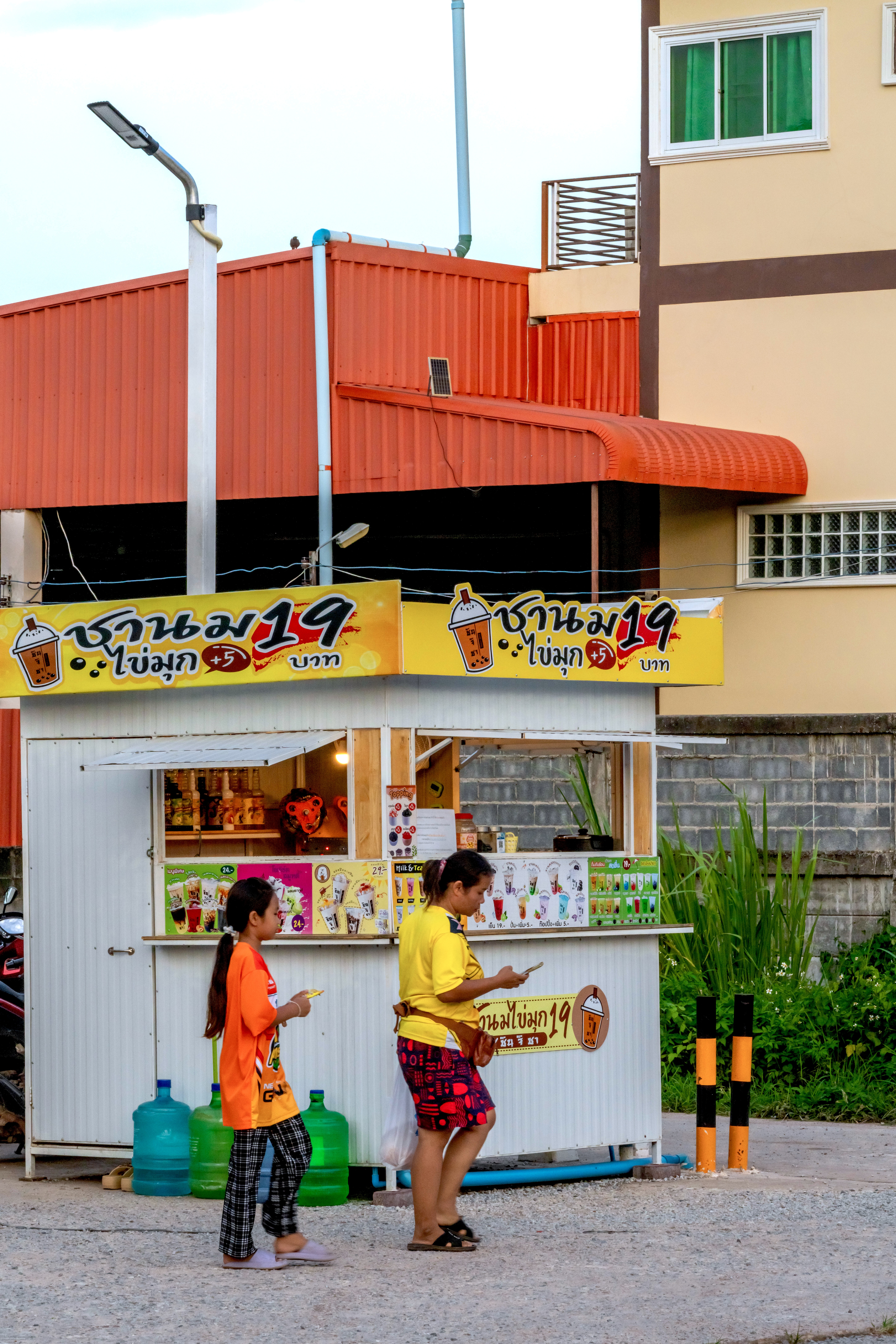 Two women in front of a bubble tea stand