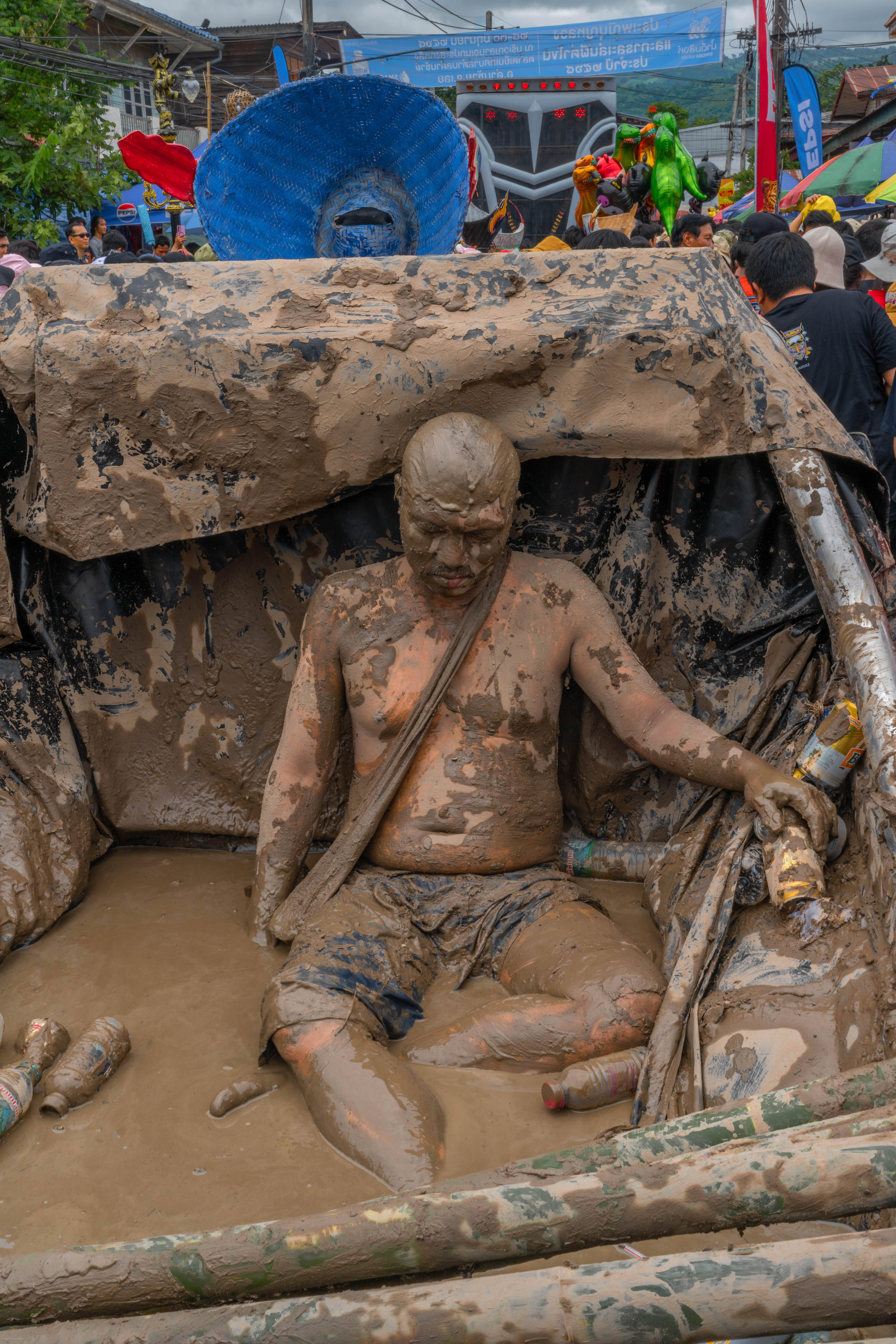 Spectacle of a drunk man covered in mud.