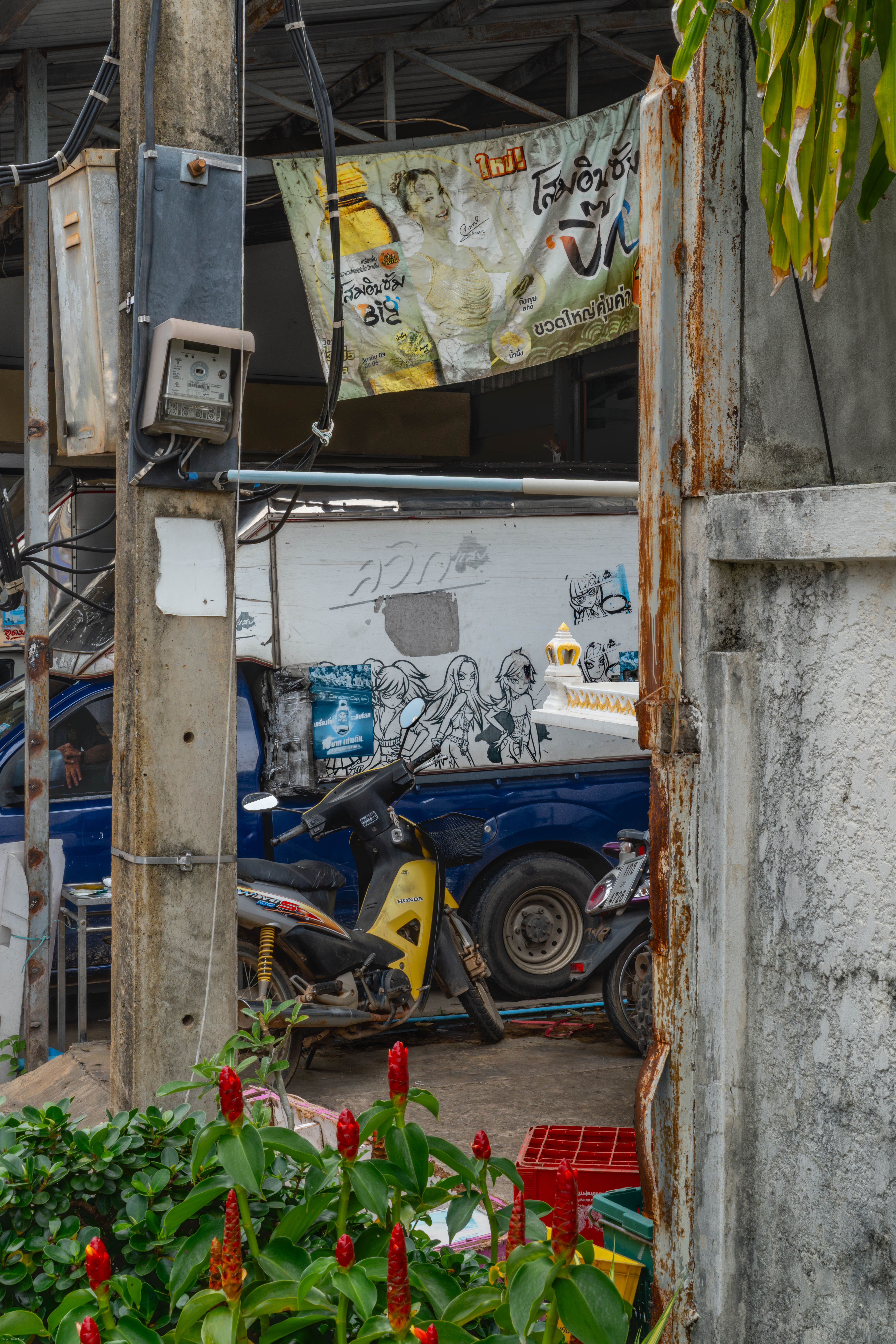Crowded shophouse with corner of spirit house showing.
