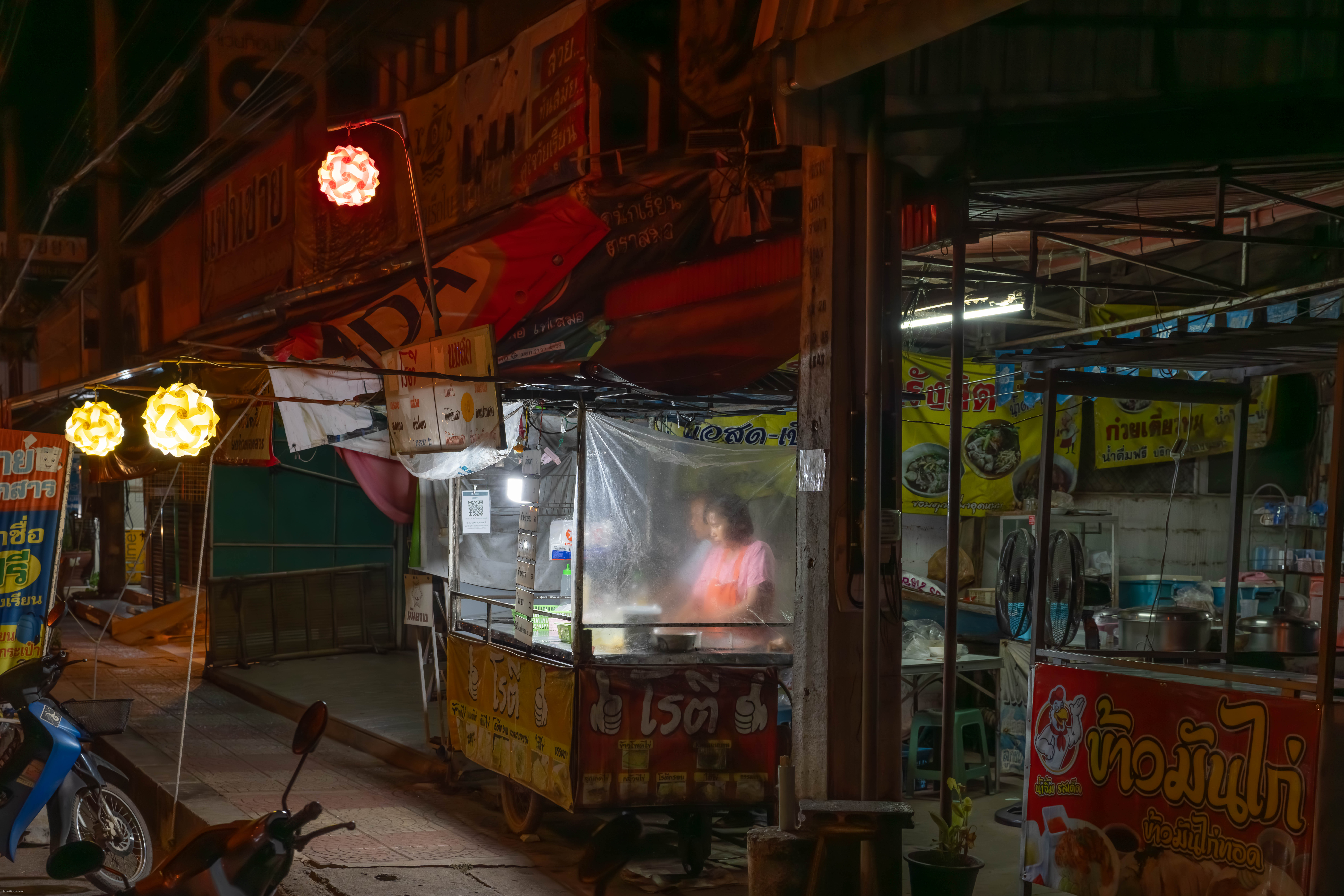 Two women in a noodle shop at night.